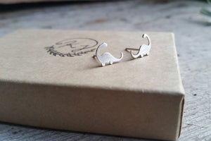 silver brontosaurus dinosaur stud earrings on a gift box