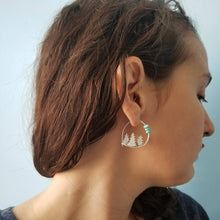 a woman wearing a silver forest hoop earring with turquoise beads