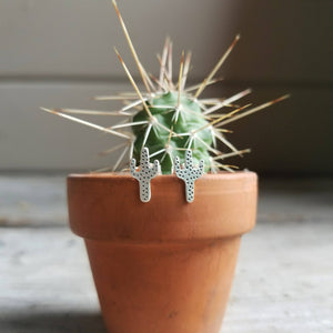 silver saguaro cactus stud earrings on a tiny potted cactus