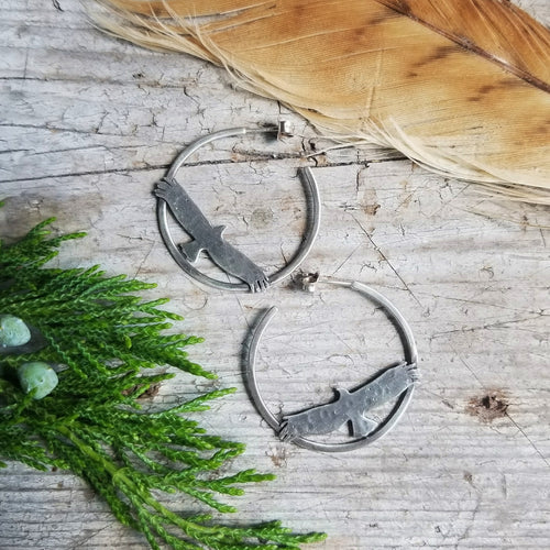 silver hawk hoop earrings with a feather and juniper sprig