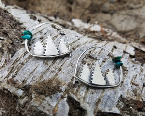 silver forest hoop earrings with turquoise beads resting on tree bark